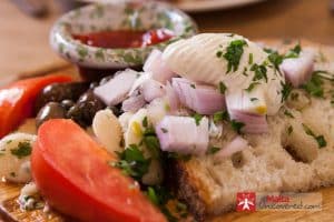 Staples of Maltese food: Gbejniet, Maltese bread, olive oil and kunserva.